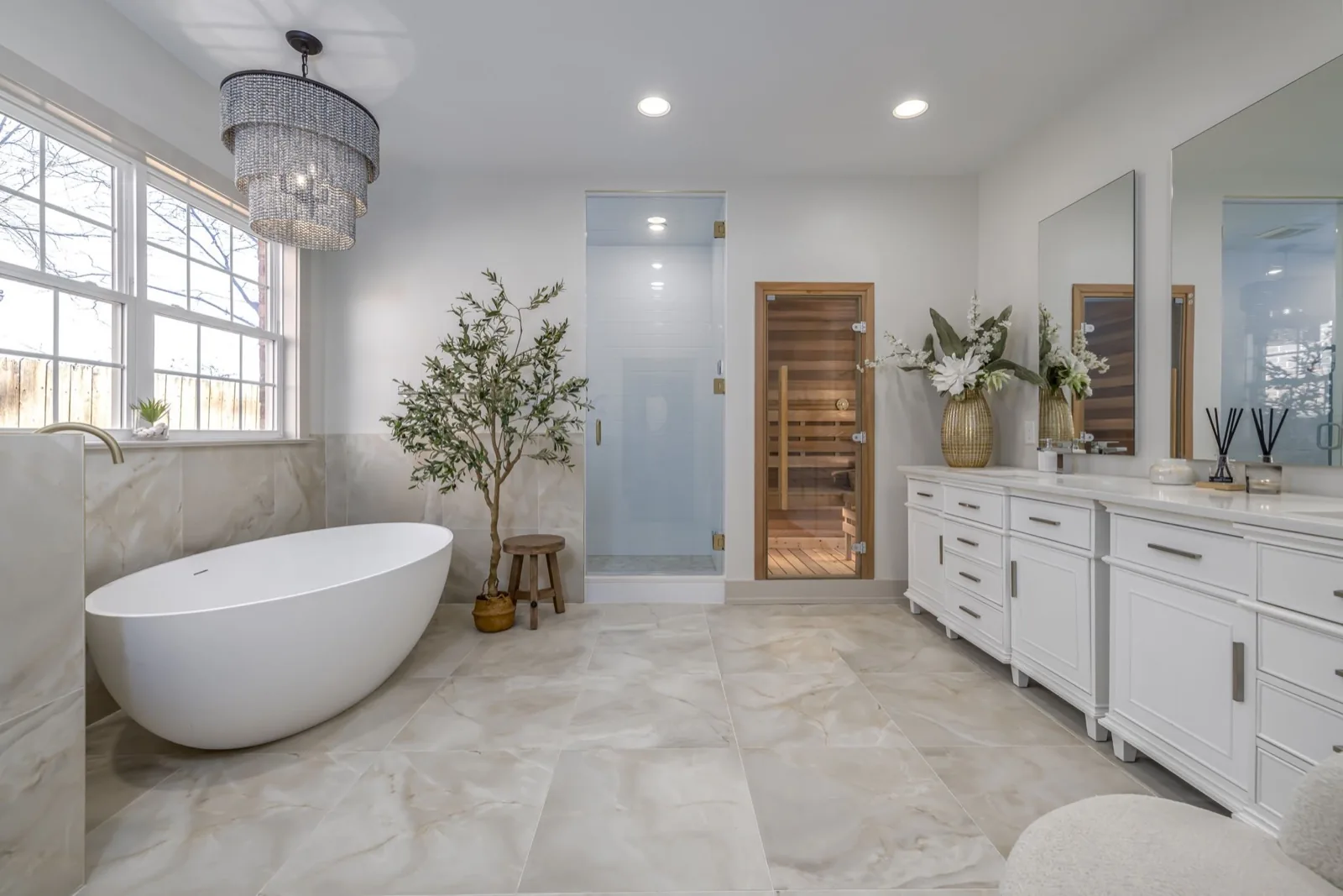 Renovated primary bathroom with freestanding tub and cedar sauna